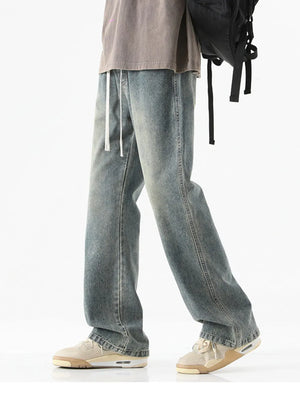 Men's light blue vintage wash cotton jeans with drawstring waist and relaxed fit.