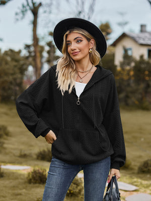Black textured knit dolman sleeve hoodie with quarter zip and front pocket.