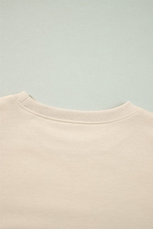 Cream sweatshirt with ribbed neckline and subtle shoulder ruffles.