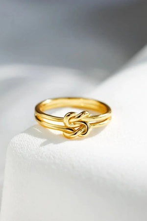 Gold double band knot ring with a minimalist design.
