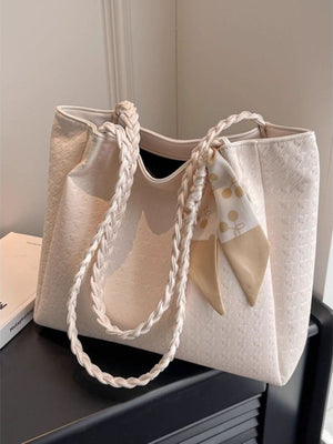 Elegant ivory shopper bag with braided handles and a decorative scarf.
