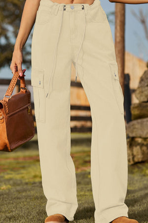 Tan utility denim cargo pants with drawstring waist and button closure.