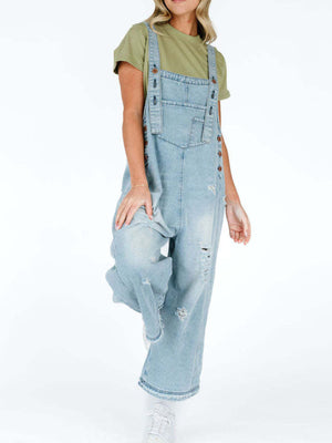 Light blue denim overalls with relaxed fit and ripped details