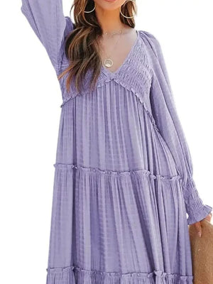 Purple smocked V-neck tiered maxi dress with long sleeves and ruffled hem.