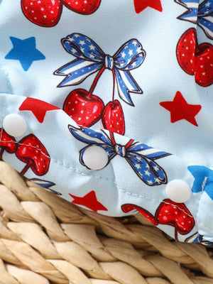 Baby one-piece with cherry and star print, featuring ruffle sleeves and snap closures.