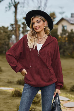 Burgundy textured cable knit zip-up hoodie with pockets and drawstring hood.