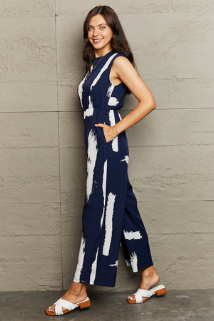 Navy brushstroke print jumpsuit with sleeveless design and wide legs.