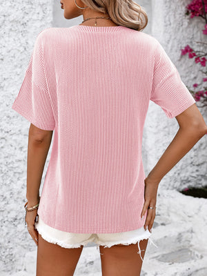 Textured ribbed blush pink V-neck tee with short sleeves and a pocket detail.