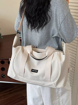 Off-white nylon travel duffle bag with curved stitching and adjustable strap.