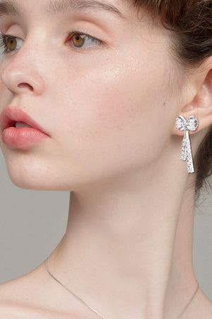 Silver baguette bow drop earrings with sparkling crystal tassels.