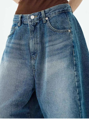 Men's blue cotton denim wide-leg shorts with button fly and faded wash.