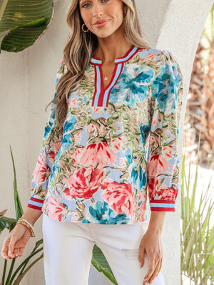 Women's cotton V-neck blouse with a bold floral print and striped trim.
