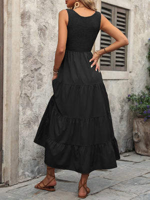 Black smocked bodice tiered maxi dress with pockets and a scoop neck.