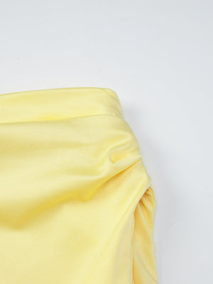 Yellow off-shoulder ruched mini dress detail showing gathered fabric and neckline.