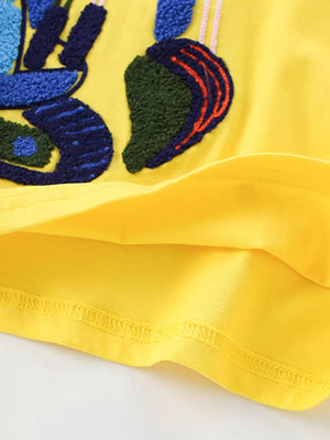 Yellow cotton t-shirt for kids with textured excavator patch detail.