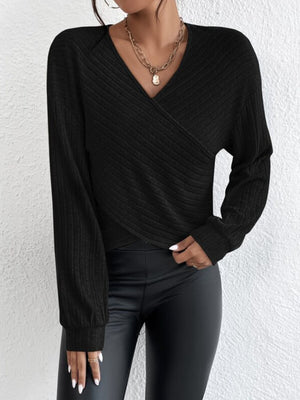 Black ribbed knit cross-front blouse with blouson sleeves and V-neck.
