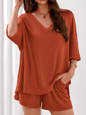 Orange-red ribbed V-neck loungewear set with relaxed fit top and shorts.