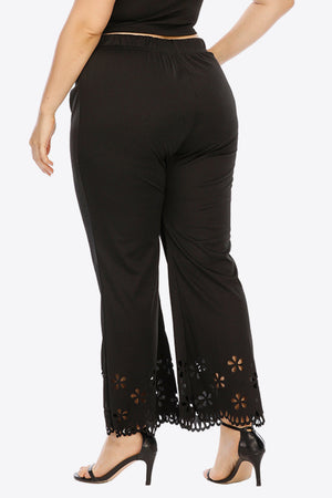 Black flare trousers with floral cutout hemline detail