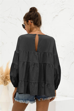 Black tiered peasant blouse with ruffled bubble sleeves and keyhole back detail.