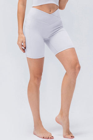 White ribbed bike shorts with a cross-waist design and side pockets.