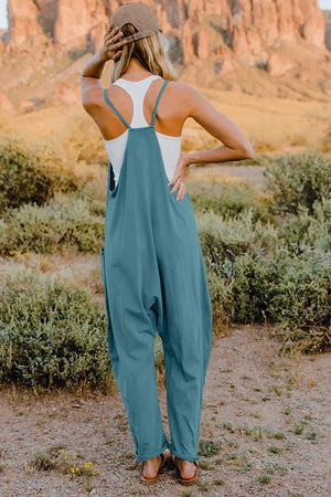 French blue cotton wide-leg jumpsuit with pockets and adjustable straps, styled with a white tank top.