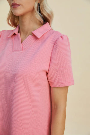 Pink textured V-neck short sleeve mini dress with geometric pattern and puff sleeves.