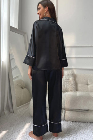 Black satin pajama set with contrast trim, relaxed fit pants and long sleeve top.