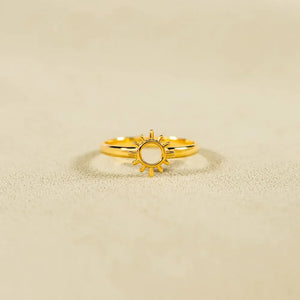 Gold sunburst signet ring with a cut-out center detail.