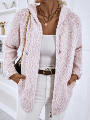 Dusty Pink textured knit zip-up cardigan with hood and logo detail, styled with a white tank and jeans.