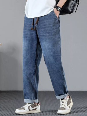 Men's blue cotton wide leg jeans with drawstring waist and cuffed hems.