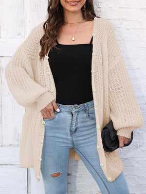 Tan balloon sleeve cardigan with pearl buttons and open front, styled with jeans.