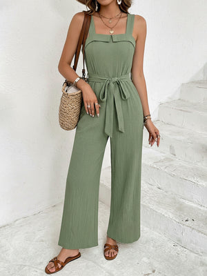 Green crinkled tie waist wide leg jumpsuit with square neckline and wide straps.