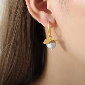 Gold hoop earrings with a pearl drop and petal detail.