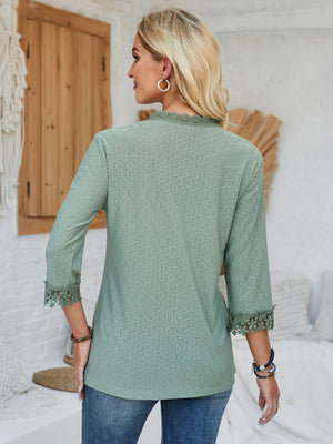 Sage green eyelet blouse with lace trim at neckline and cuffs.