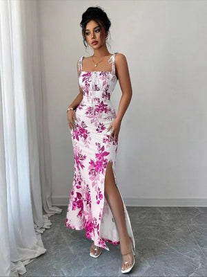 White floral print maxi dress with tie straps, ruched bodice, and high slit.