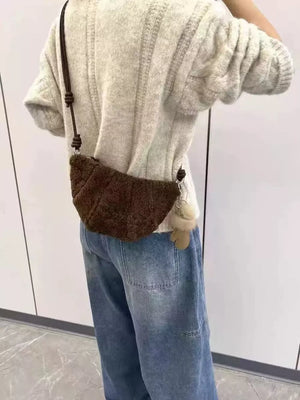 Plush knot strap furry crossbody bag in brown with a fluffy charm.