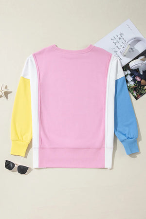 Colorblock sweatshirt in pink, white, yellow, and blue with crewneck and long sleeves.