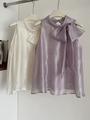 Sleeveless purple shirt with a large bow detail at the neckline.