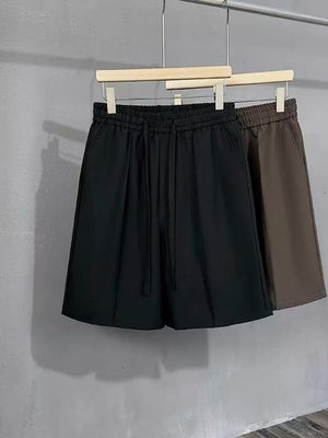 Black and brown men's chino shorts with drawstring waist and pleats.