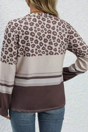 Leopard print crewneck top with horizontal stripes and long sleeves.