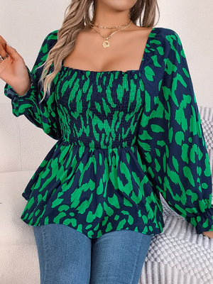 Smocked bodice square neck blouse in navy with green animal print, long sleeves, and peplum hem.