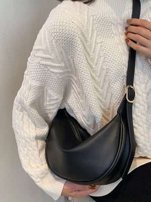 Black pu leather crescent crossbody bag with gold buckle detail.