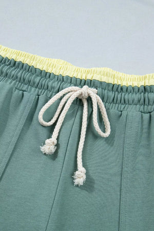 Green cotton sweatpants with yellow waistband and white drawstring.