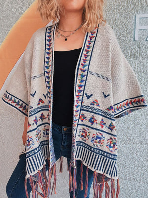 Apricot kimono with embroidered trim and colorful fringe hem, featuring geometric patterns.