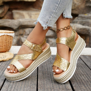 Gold crocodile-embossed platform sandals with adjustable buckle and ankle strap.
