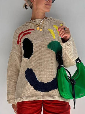 Tan knit sweater with abstract graphic face, long sleeves, crew neck.