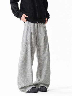 Men's gray wide-leg drawstring pants with a relaxed fit and subtle pleating.