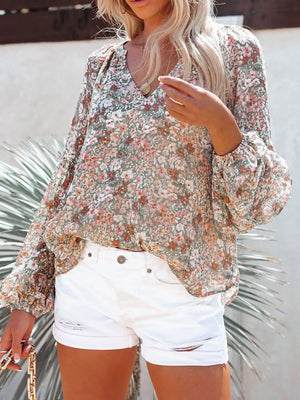Floral print V-neck long sleeve maternity shirt with bishop sleeves and a green, pink, and white floral pattern.