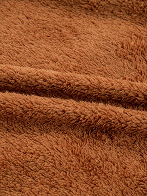 Cozy brown plush fabric texture detail of a zippered vest coat