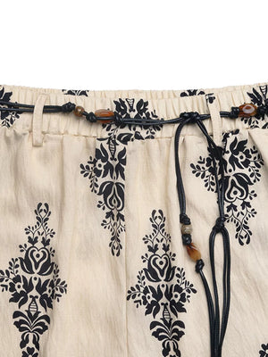Beige maternity wide leg trousers with black boho print and beaded drawstring.